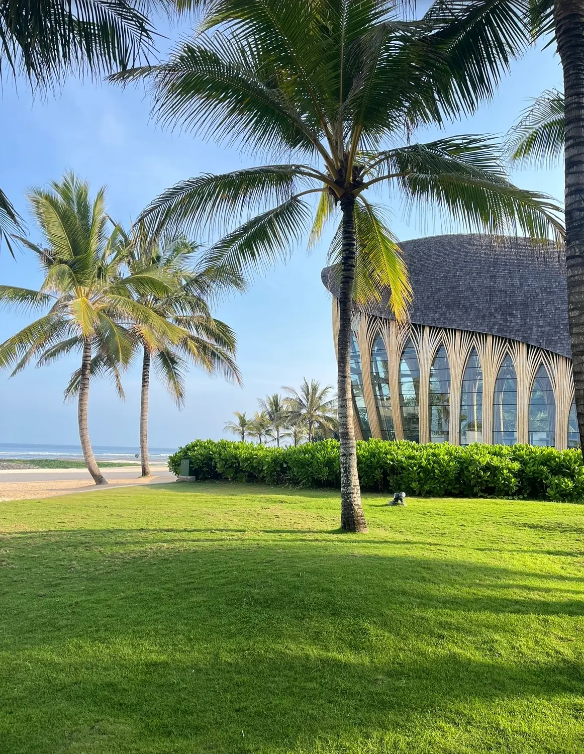 Palm trees framing a beachfront resort pavilion