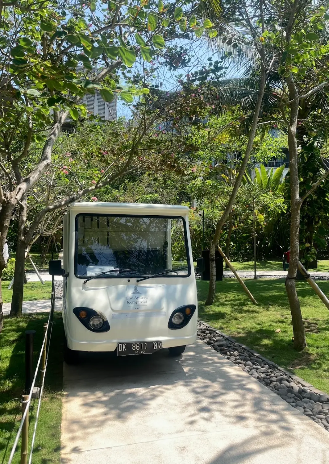 White resort shuttle buggy on a garden path