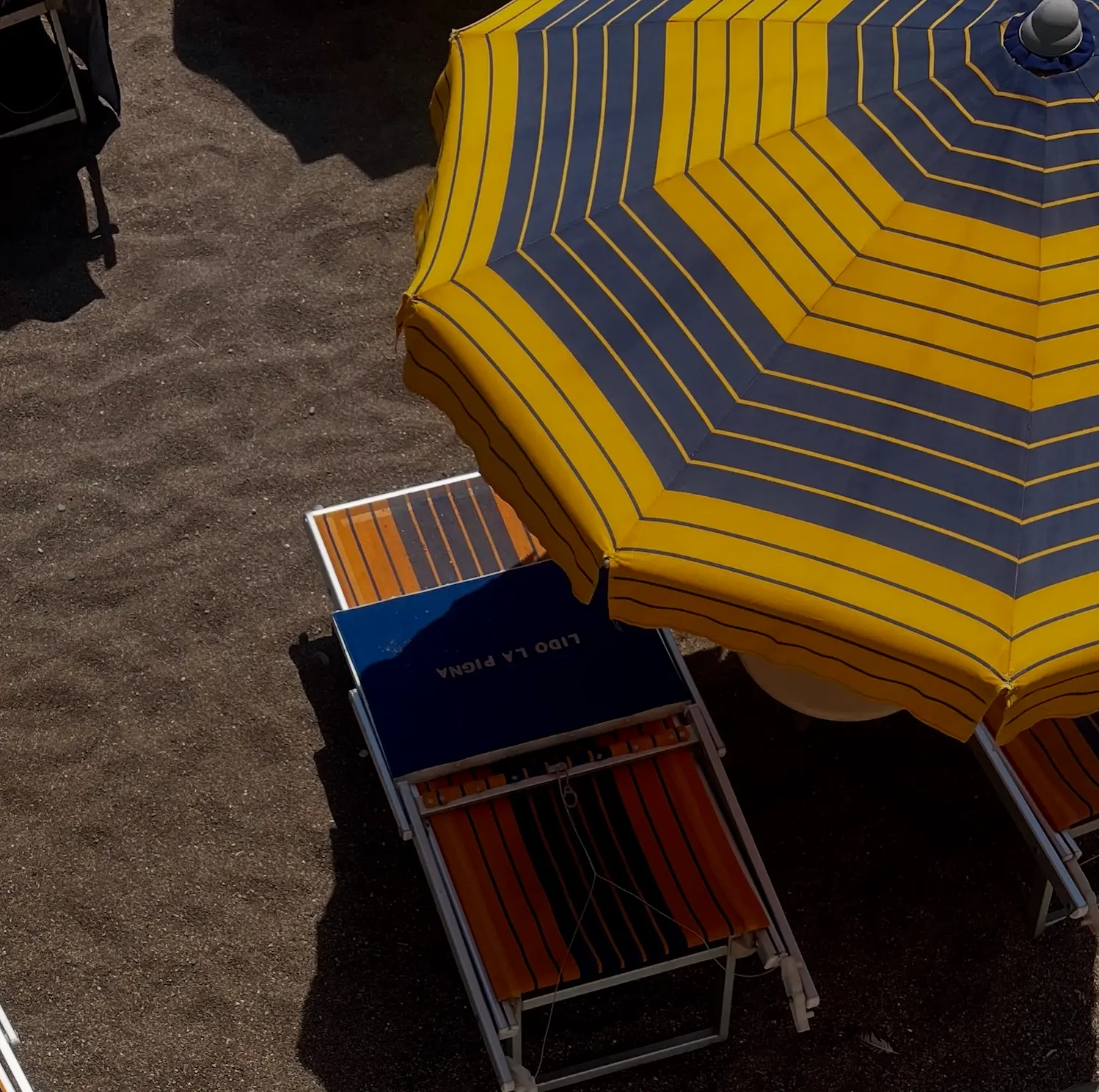 Striped beach umbrella from above